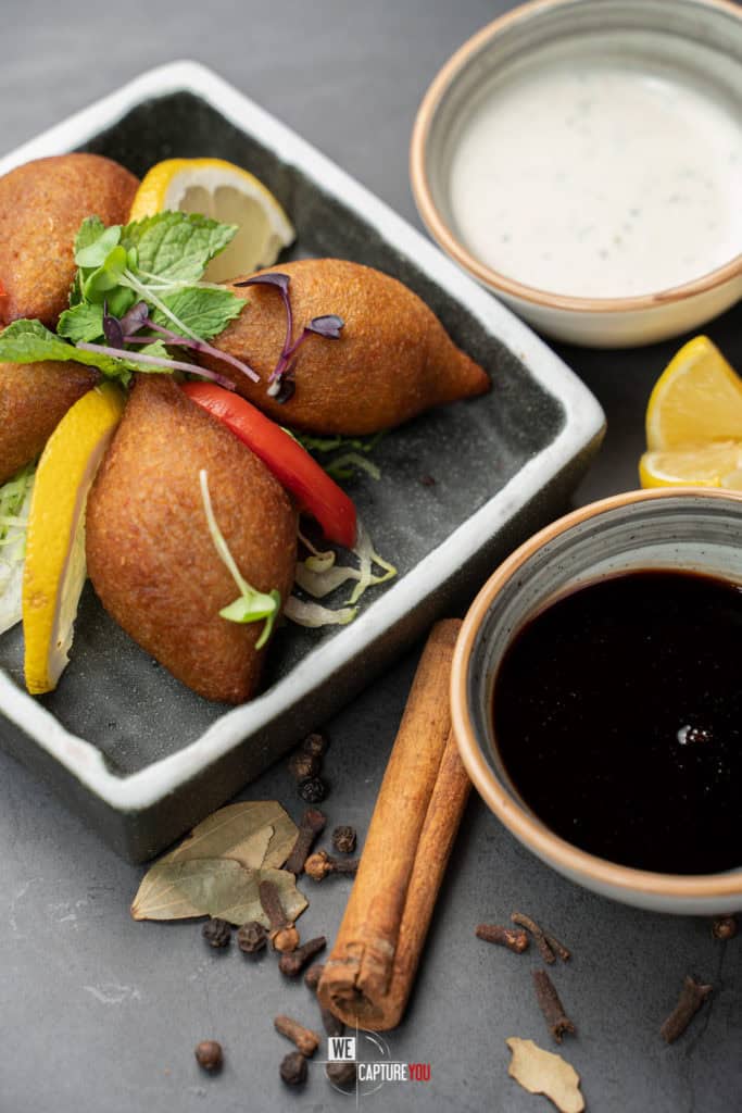 Delicious Middle Eastern falafel with dipping sauces and fresh lemon slices.