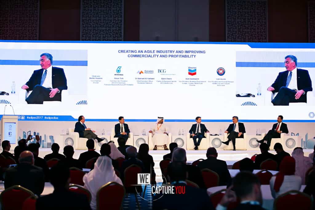 Panel discussion at a business conference with speakers and audience.