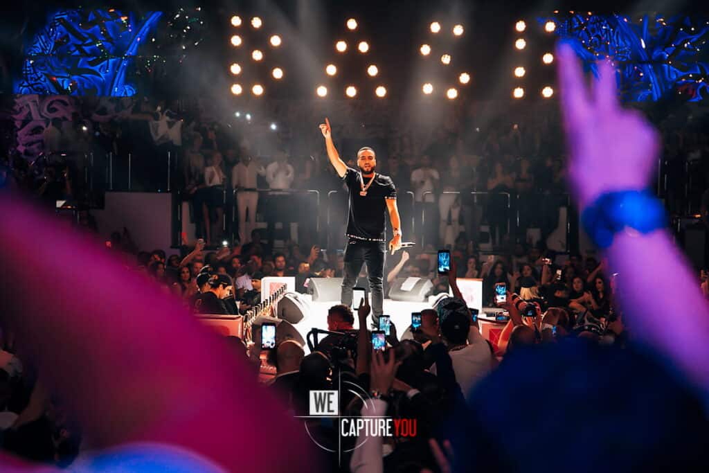 Performer on stage at WeCapture event with audience capturing the moment.
