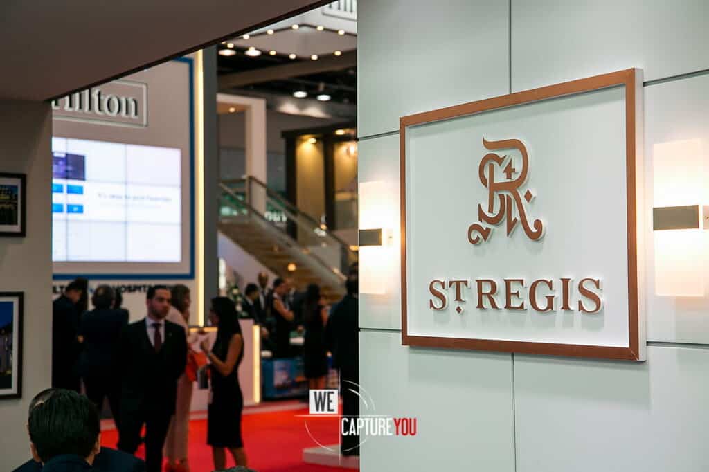 St. Regis logo displayed at a busy trade show event.