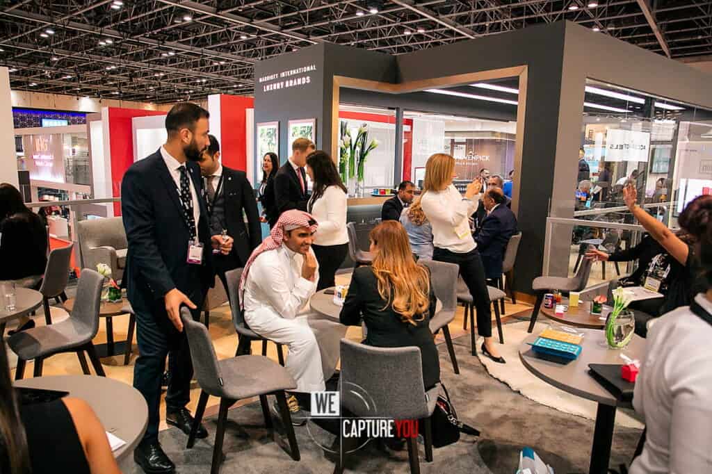 Business professionals networking and discussing at trade show booth.