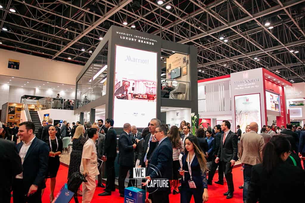 Crowd of professionals at WeCapture booth during a trade show.
