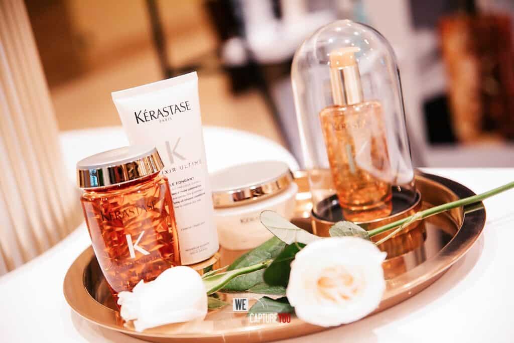 Elegant display of Kérastase hair care products with flowers and decorative elements.