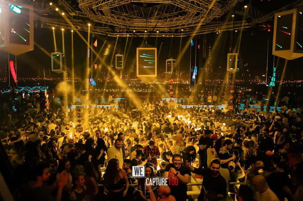 Crowd dancing and enjoying music at a lively nightclub event.