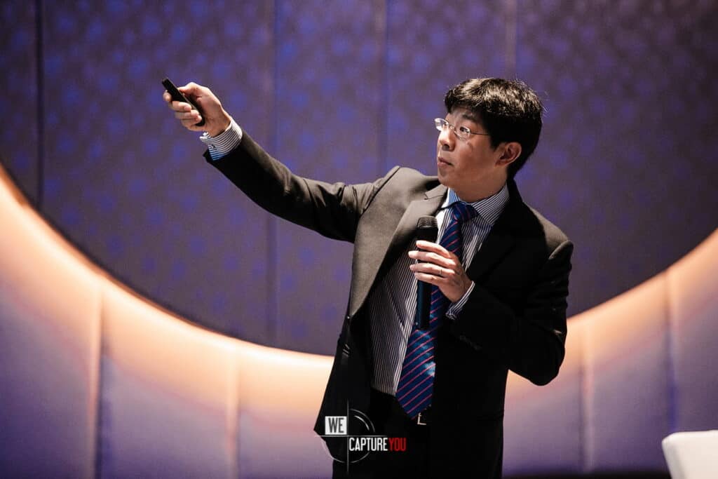 Businessman giving a presentation with a microphone and remote control.