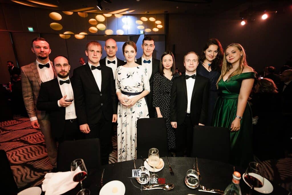 Group of elegantly dressed people at a formal event or dinner.
