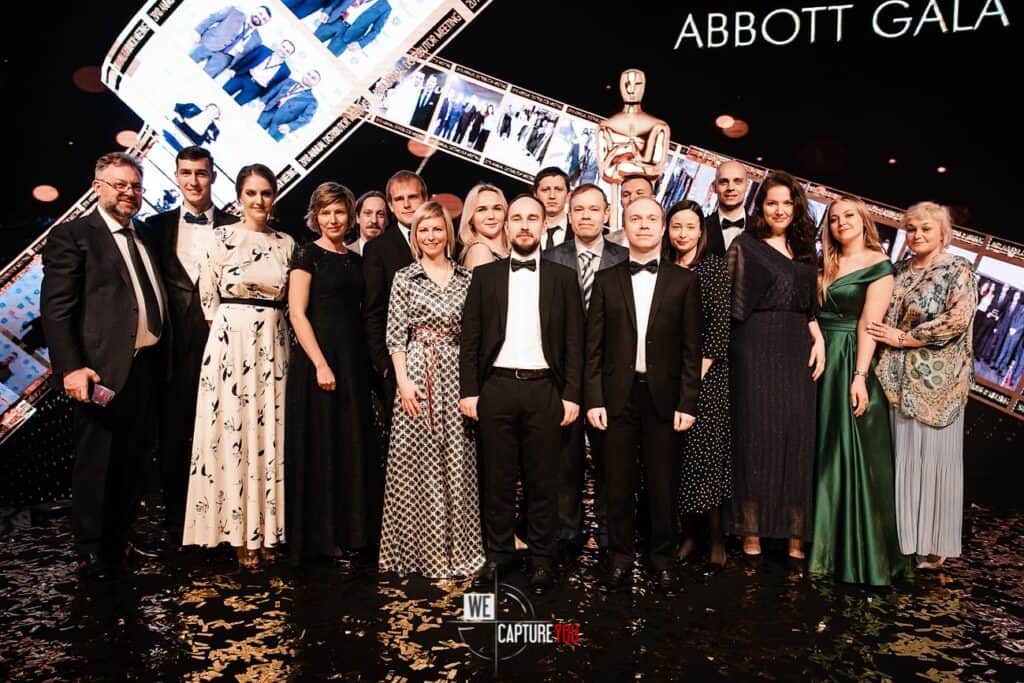 Group of people at Abbott Gala event with awards and decorations.