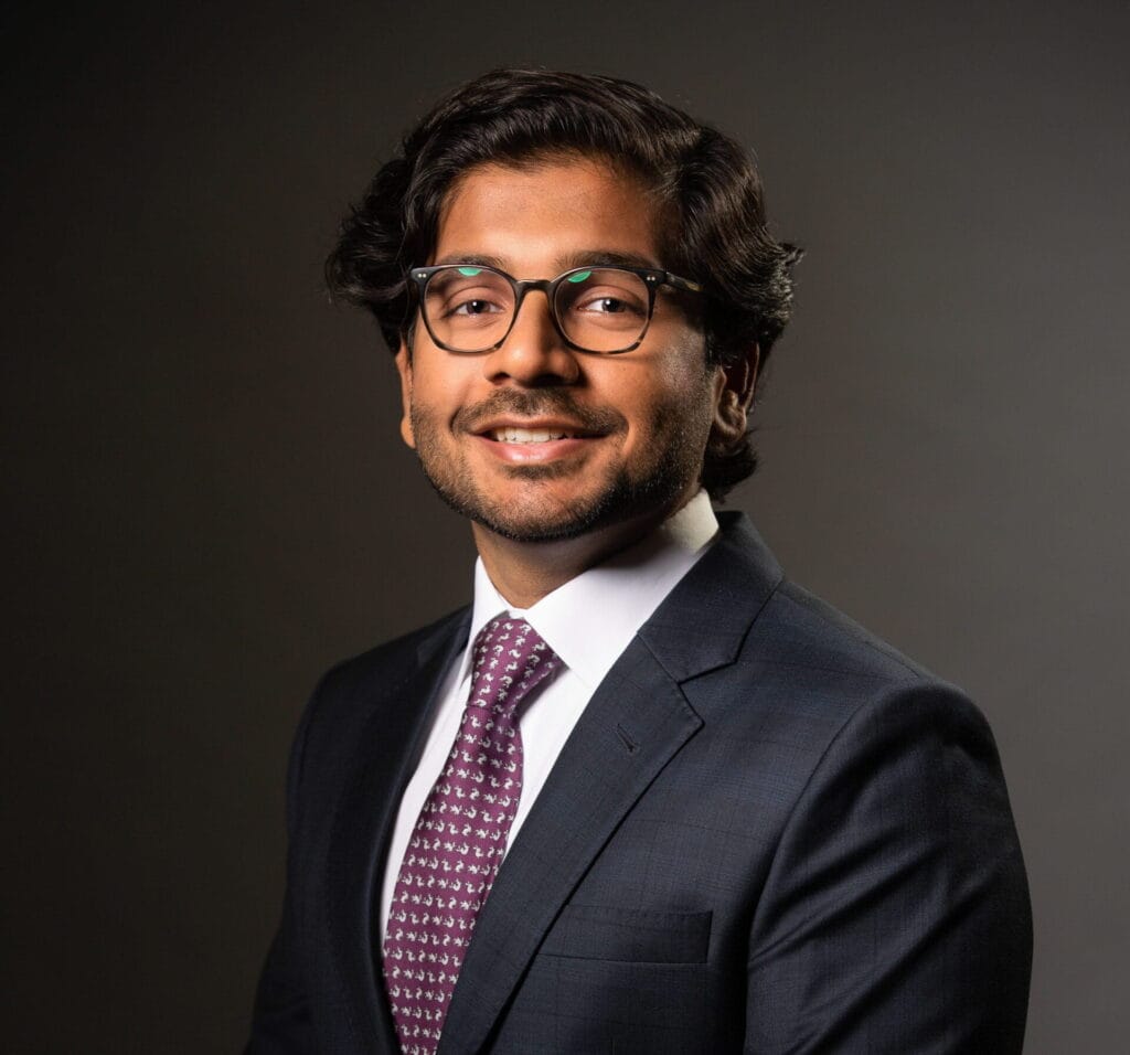 Business professional in suit with glasses smiling for WeCapture.