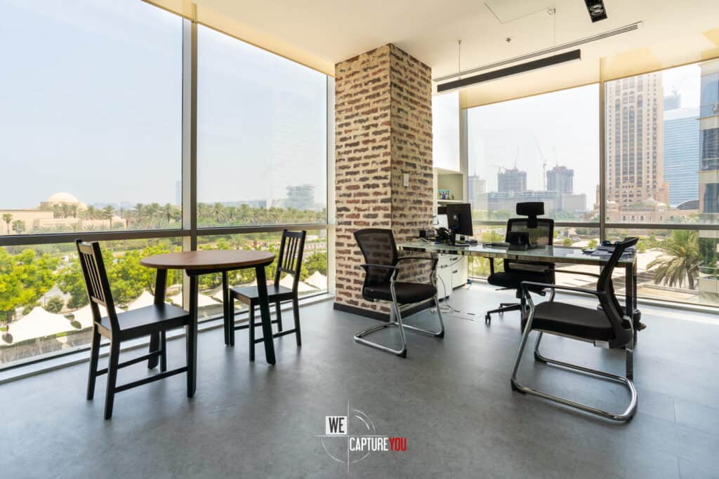 Bright office with large windows and city skyline view.