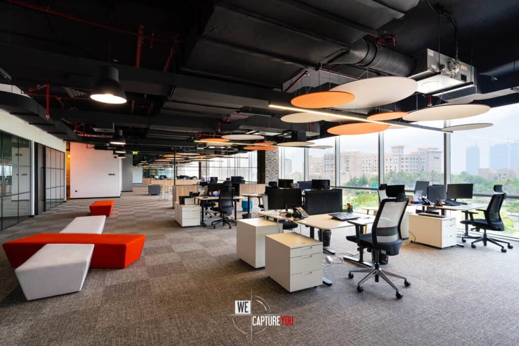 Spacious modern office with desks, chairs, and creative ceiling design.