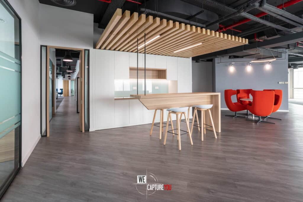 Contemporary office space with wooden accents and vibrant red seating area.