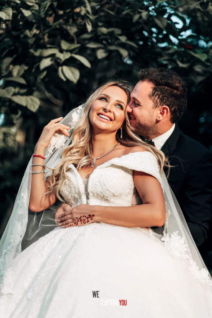 Beautiful bride and groom smiling outdoors on their wedding day.