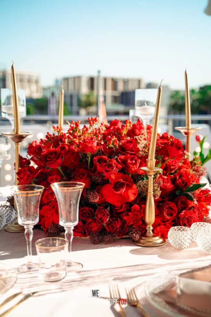 Beautiful wedding table with red roses and candles for a romantic celebration.