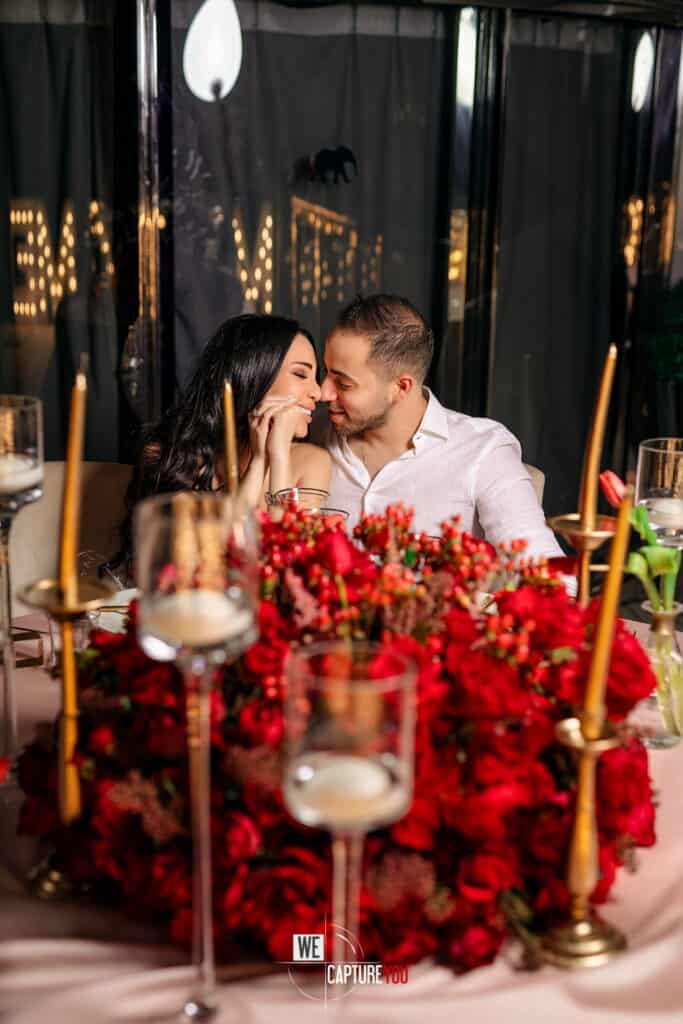 Couple sharing a romantic moment at a decorated dinner table.