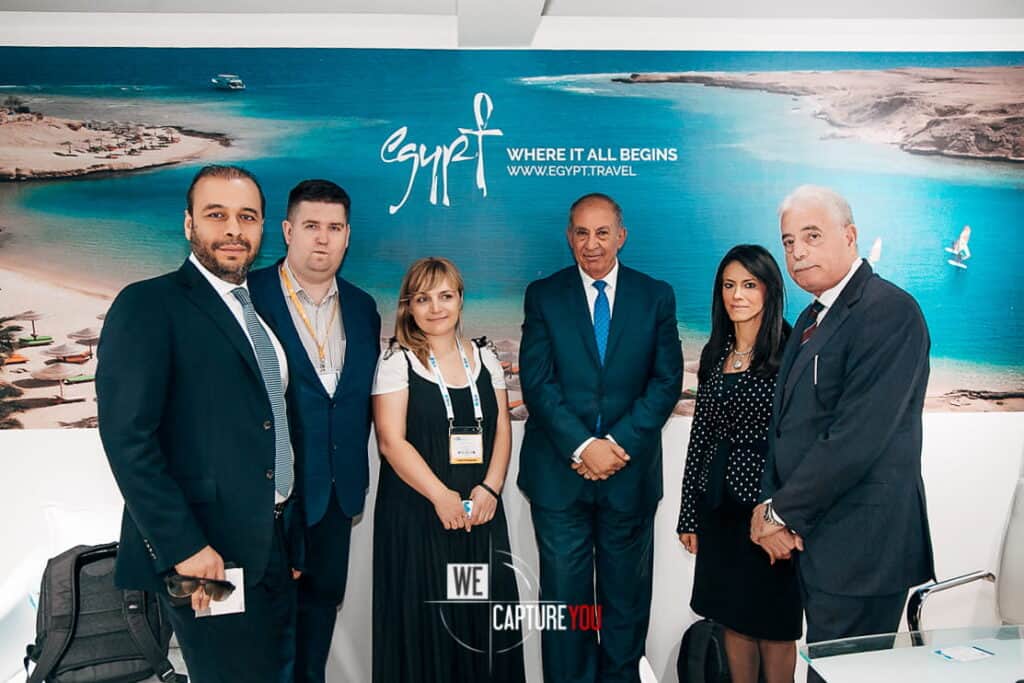 Group of professionals at Egypt travel event with scenic backdrop.