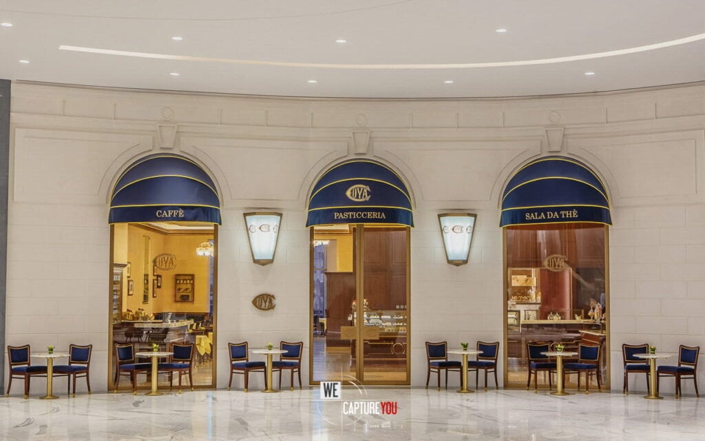 Stylish cafe and patisserie with seating area and decorative lighting.