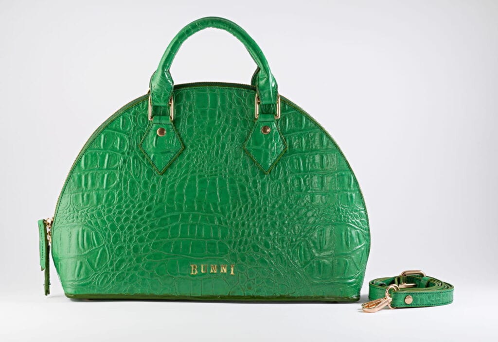Stylish green crocodile-embossed handbag with detachable strap and gold accents.