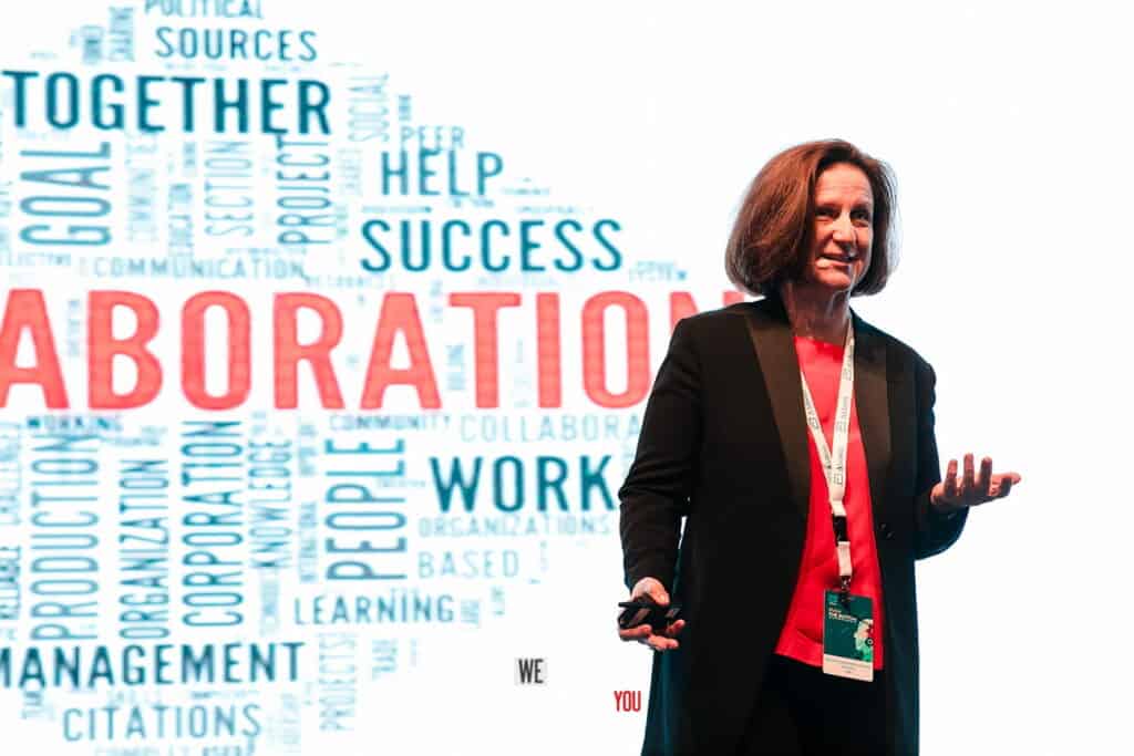 Woman presenting on collaboration, teamwork, and success at a conference.