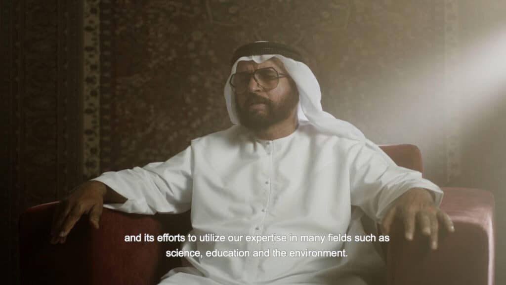Middle Eastern businessman wearing glasses and traditional attire in a professional setting.