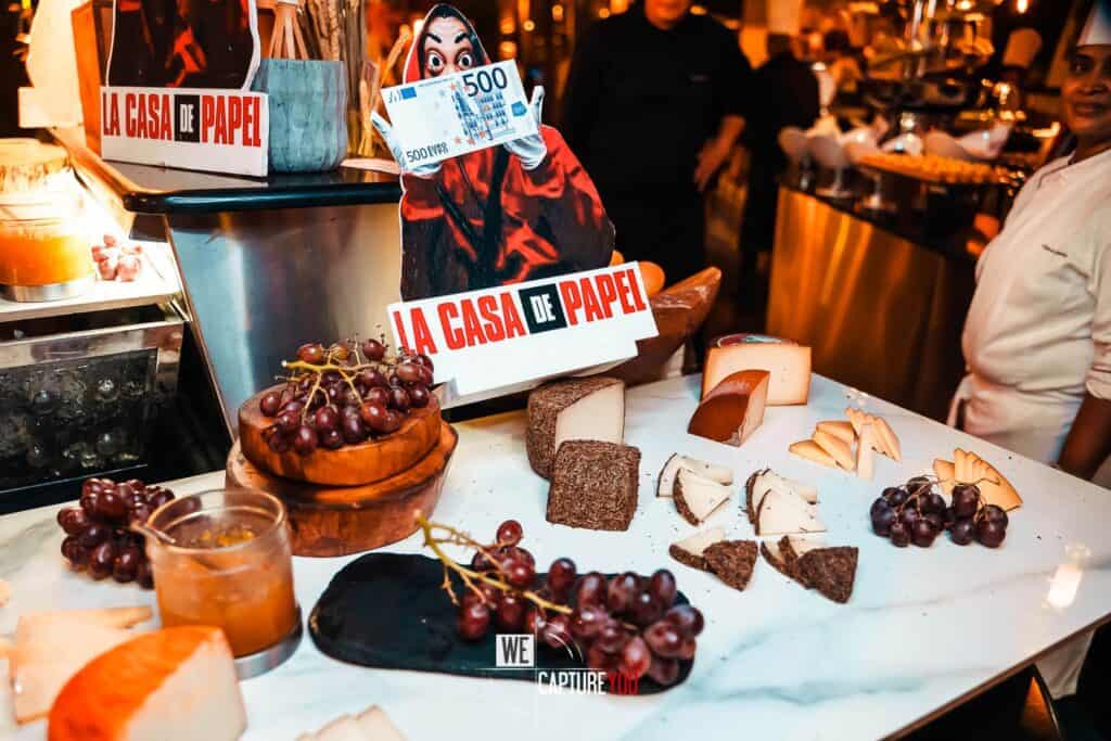 Cheese, grapes, and wine at a lively cheese tasting event.