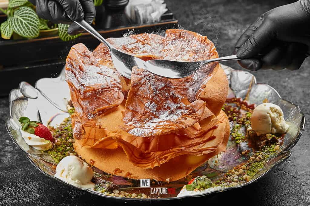 Close-up of a dessert with crispy wafer and ice cream on a decorative plate.