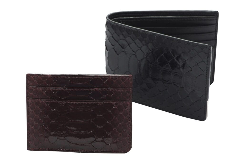 Two snake-patterned wallets, one black and one burgundy, on a white background.