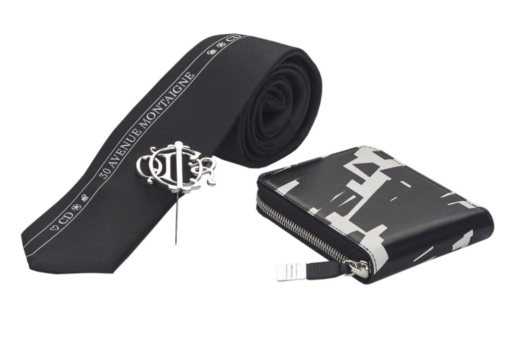 Black and white fashion accessories including a tie, wallet, and pin.