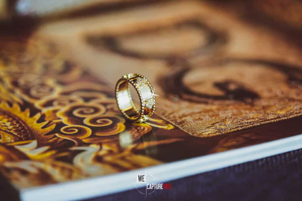 Close-up of wedding rings on artistic book cover for wedding photography.