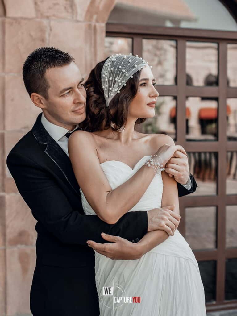 Beautiful bride and groom embracing outdoors during wedding celebration.