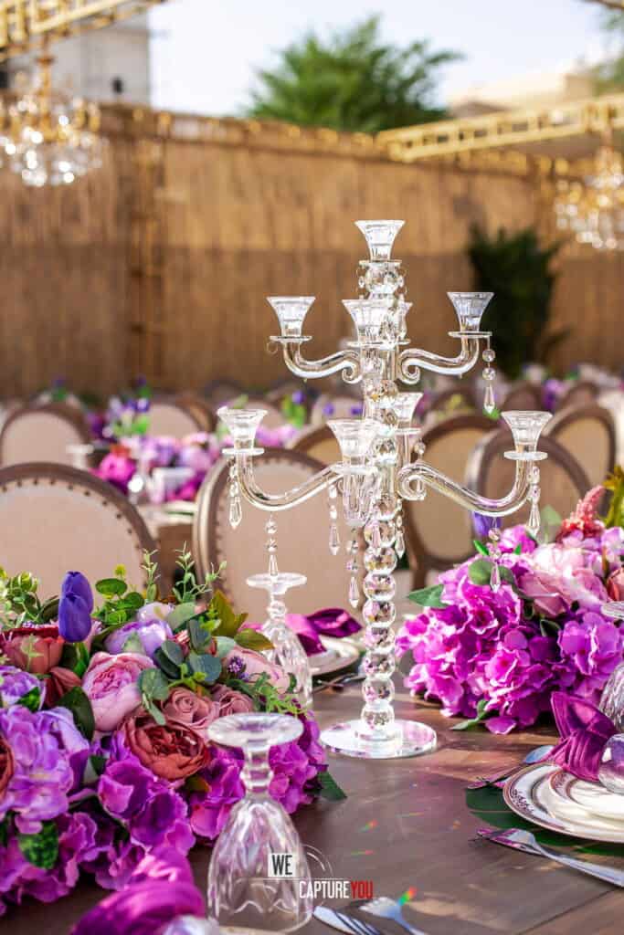 Beautiful wedding table with crystal candelabrum and vibrant purple flowers.
