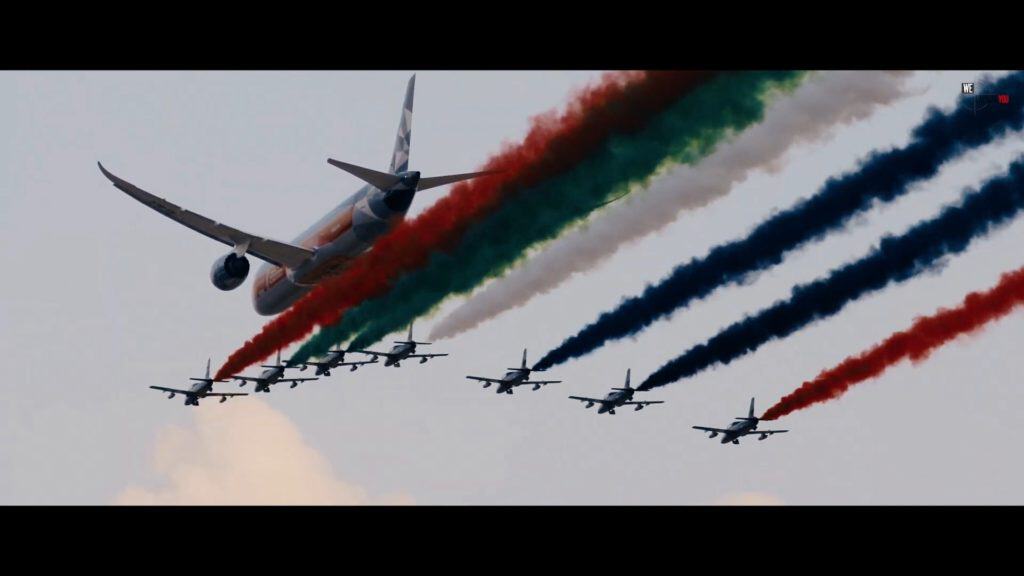 F-16 fighter jets perform an air show with colorful smoke trails at Abu Dhabi Grand Prix.