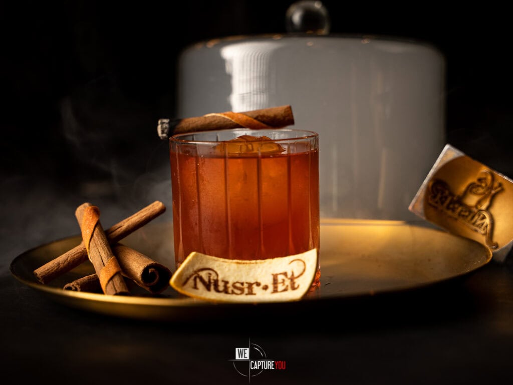 A glass of hot spiced tea with cinnamon sticks on a dark background.