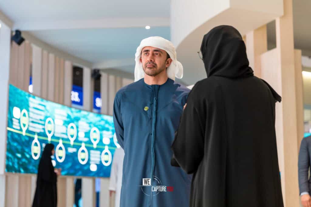 Two professionals in traditional attire engaging at Abu Dhabi Sustainable Week.