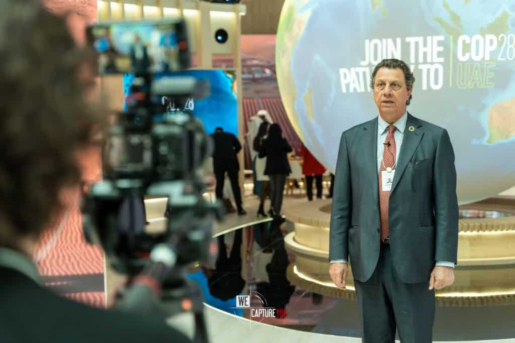 Man in suit speaking at COP28 UAE climate conference in Abu Dhabi.
