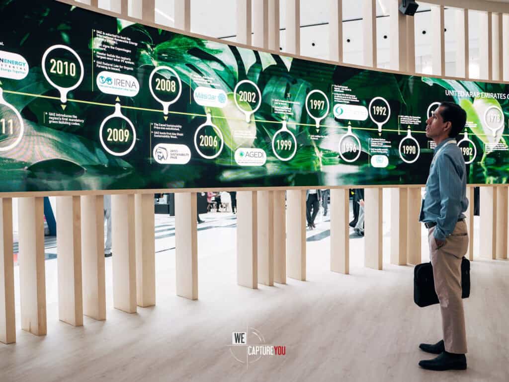 Man viewing a green sustainability timeline at Abu Dhabi Sustainable Week.