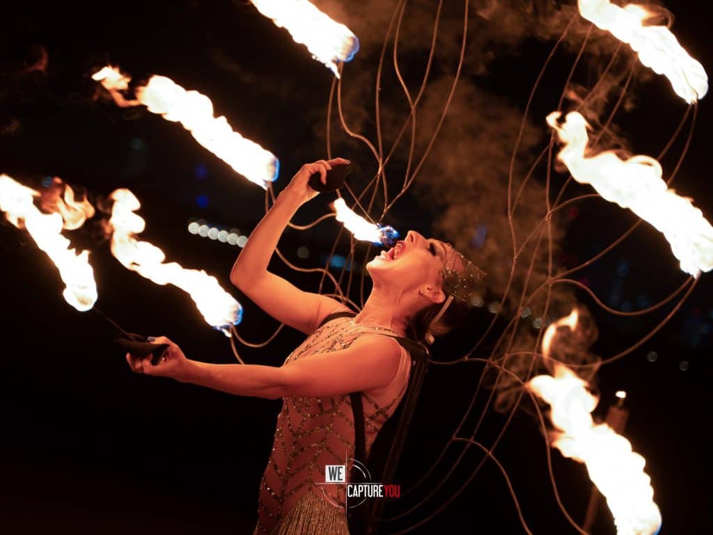 Performer breathing fire during a Dubai event with flames and sparks.