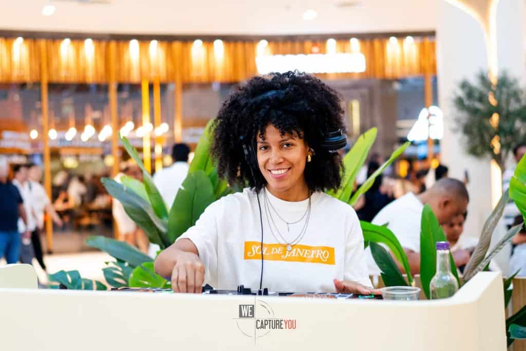 DJ playing music at SEPHORA Sol de Janeiro event with lush greenery.