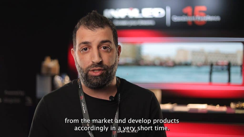 Man speaking at Infieled CABSAT 2024 exhibition with a blurred background.