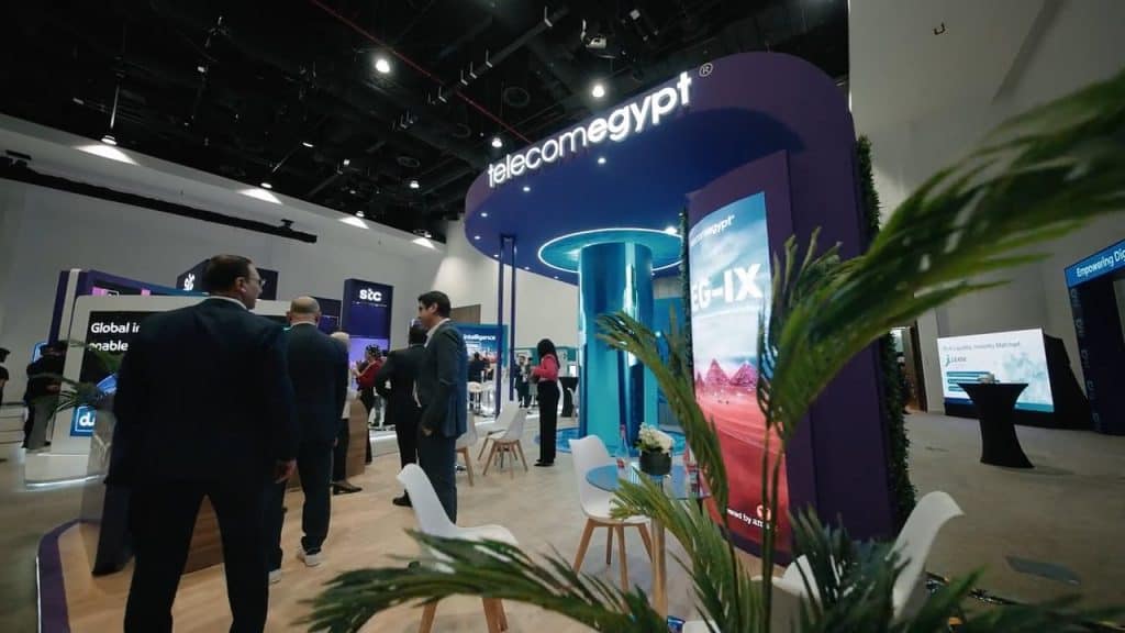 Telecom Egypt Dubai Exhibition 2026 booth with attendees and digital displays.