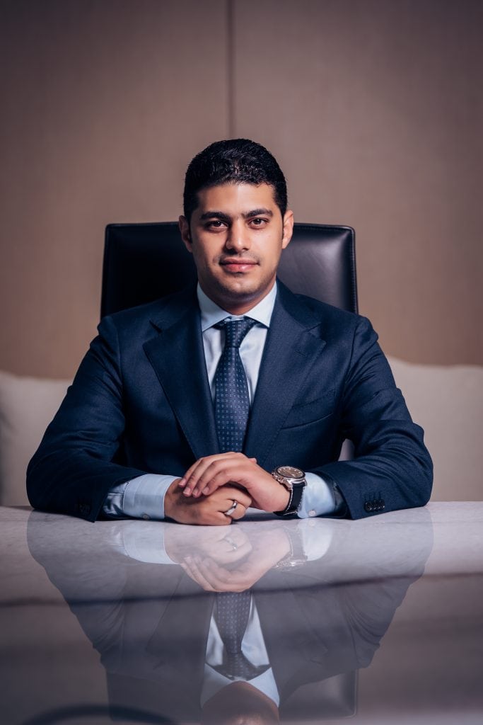 Professional corporate headshot of a young businessman in a suit.